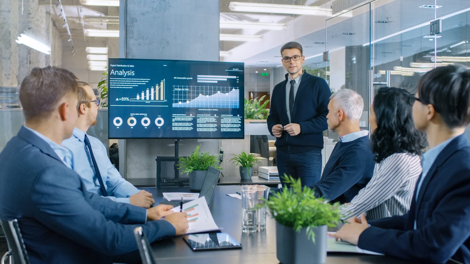 Valuation experts team discussing in a meeting by showing analysis bar charts on projector